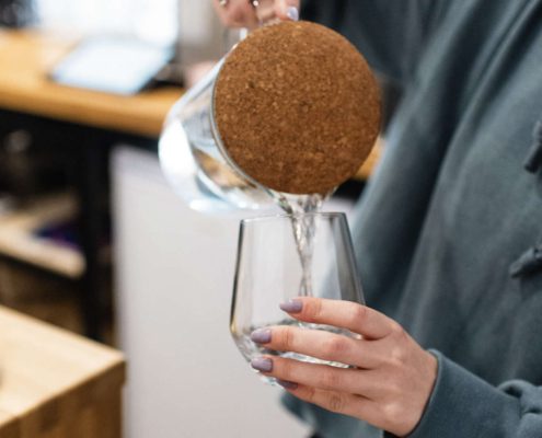 Person pouring water into a glass, representing the importance of testing for bacteria like E. coli