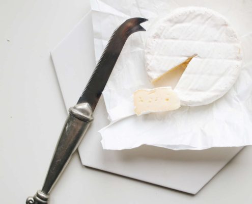 Soft cheese with a slice cut out, representing food products tested for pathogens