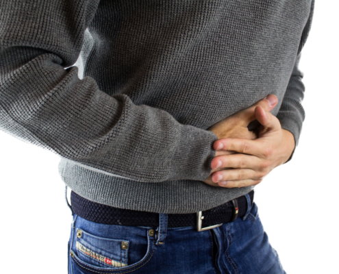 Person clutching stomach, representing gastrointestinal symptoms from copper-contaminated water